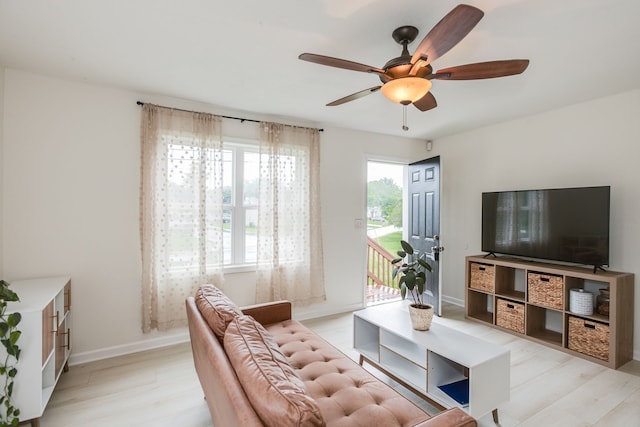 living room with ceiling fan and light hardwood / wood-style flooring