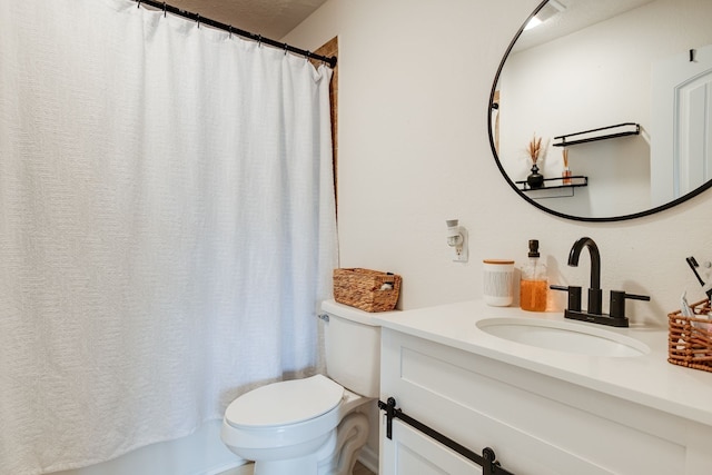 bathroom with toilet, vanity, and a textured ceiling