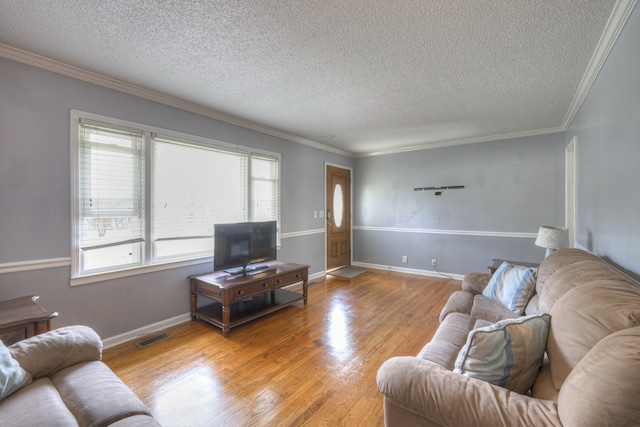 living room featuring a textured ceiling, light wood-type flooring, and crown molding