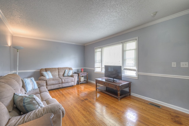 living room with hardwood / wood-style floors, a textured ceiling, and crown molding