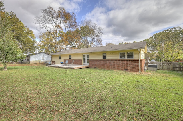 back of house featuring a lawn and a deck