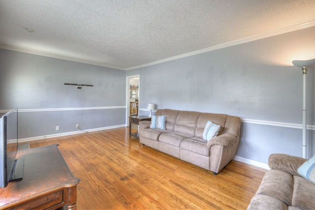 living room with hardwood / wood-style floors, a textured ceiling, and ornamental molding