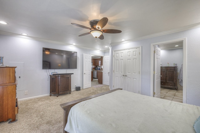 carpeted bedroom featuring a closet, crown molding, ceiling fan, and ensuite bathroom