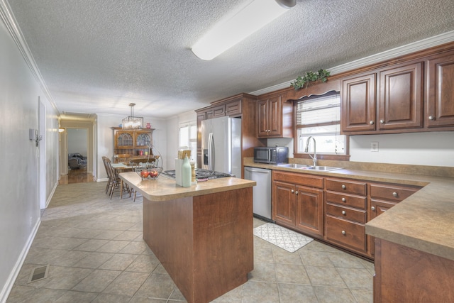 kitchen featuring stainless steel appliances, a center island, sink, ornamental molding, and pendant lighting