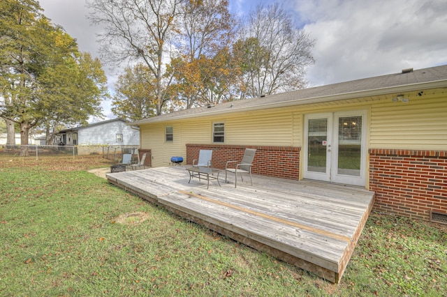 rear view of house featuring a wooden deck and a yard