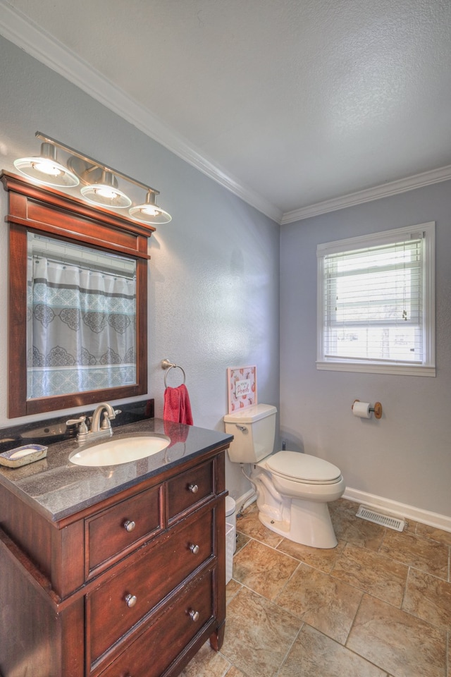 bathroom with ornamental molding, vanity, and toilet