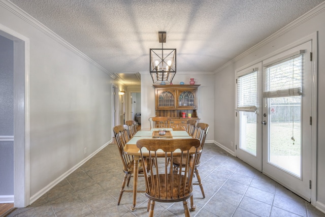 tiled dining room featuring an inviting chandelier, a textured ceiling, ornamental molding, and french doors