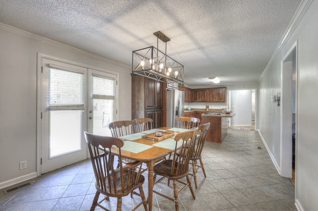 dining space with light tile patterned flooring, a textured ceiling, a notable chandelier, and ornamental molding