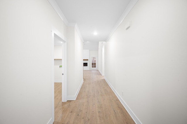 hall featuring light wood-type flooring and crown molding