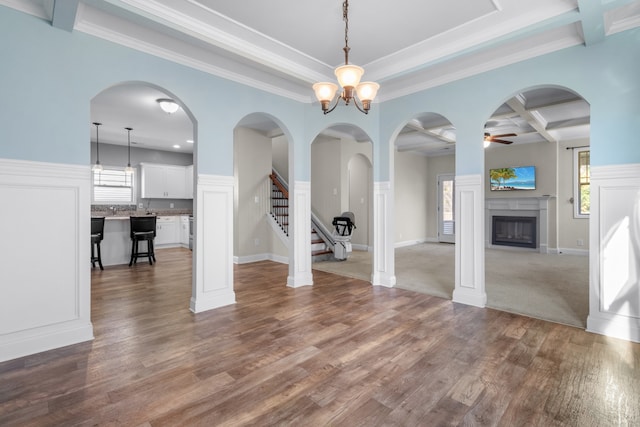 interior space with wood-type flooring, crown molding, and coffered ceiling