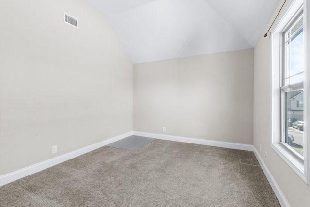 empty room with lofted ceiling and carpet floors