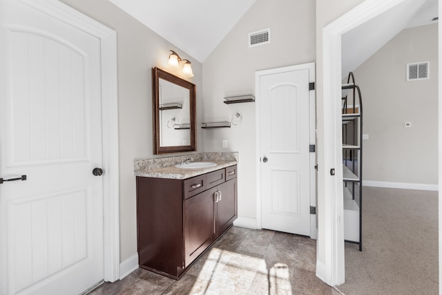 bathroom featuring vanity and lofted ceiling