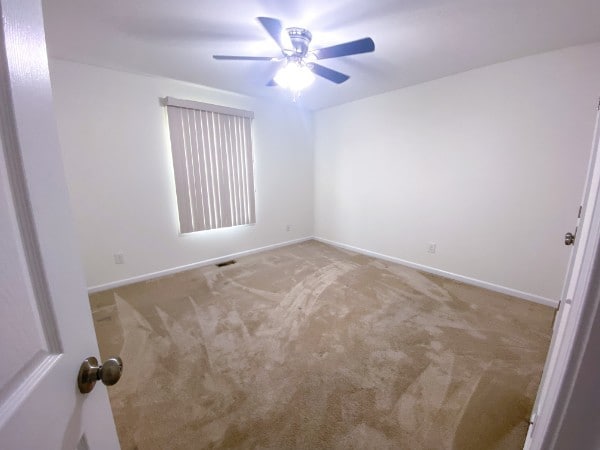 empty room with light colored carpet and ceiling fan