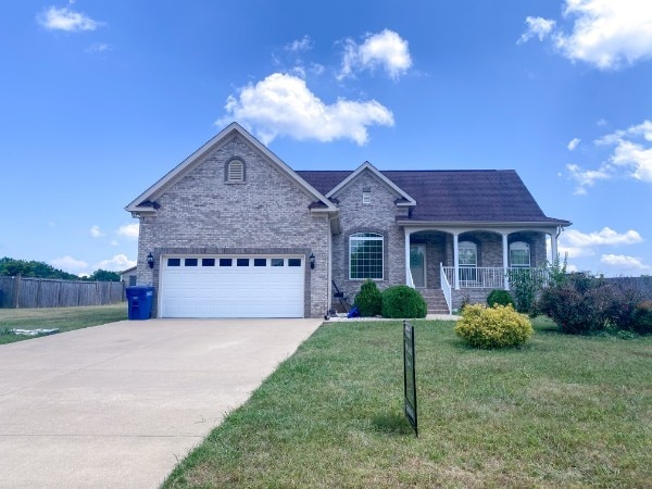 view of front facade featuring a garage, a front yard, and covered porch