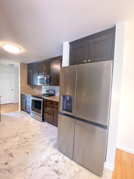 kitchen featuring appliances with stainless steel finishes, decorative backsplash, and dark brown cabinets