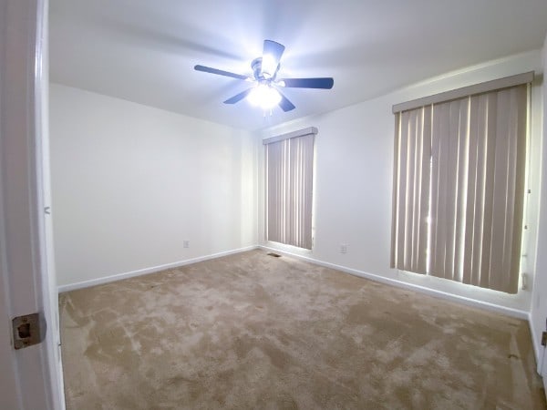 carpeted empty room with ceiling fan