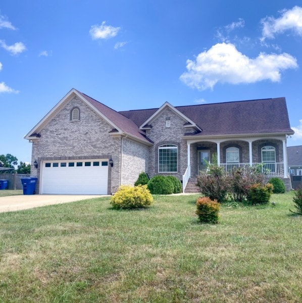 single story home with a front lawn, a garage, and covered porch