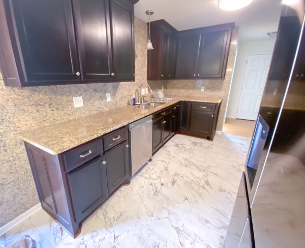 kitchen with sink, light stone countertops, backsplash, pendant lighting, and dishwasher