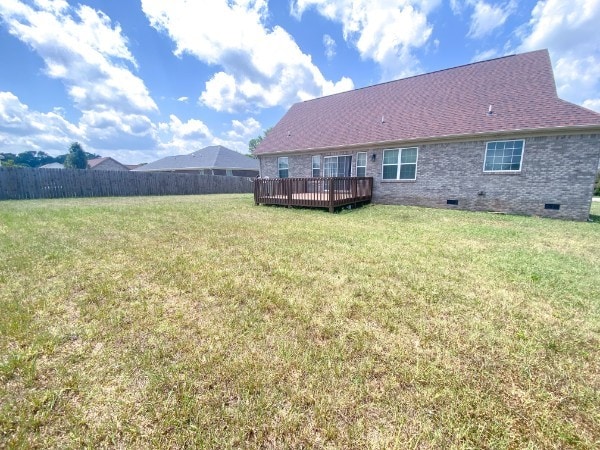 rear view of property with a yard and a wooden deck