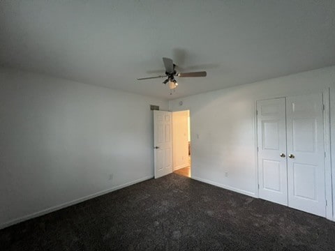 unfurnished bedroom with carpet flooring, ceiling fan, and a closet