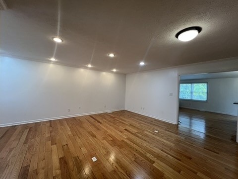 spare room with hardwood / wood-style floors and a textured ceiling