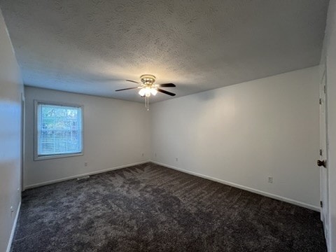 carpeted spare room featuring a textured ceiling and ceiling fan