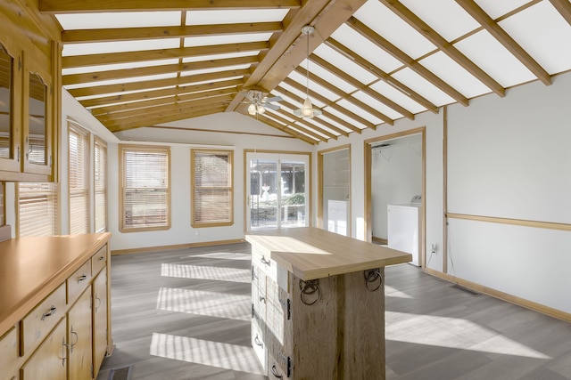 unfurnished sunroom featuring washer / dryer, vaulted ceiling with beams, and ceiling fan