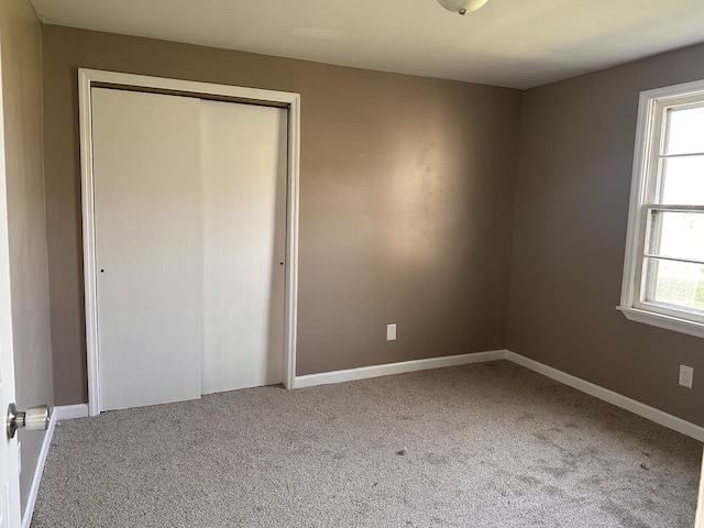 unfurnished bedroom featuring carpet flooring and multiple windows