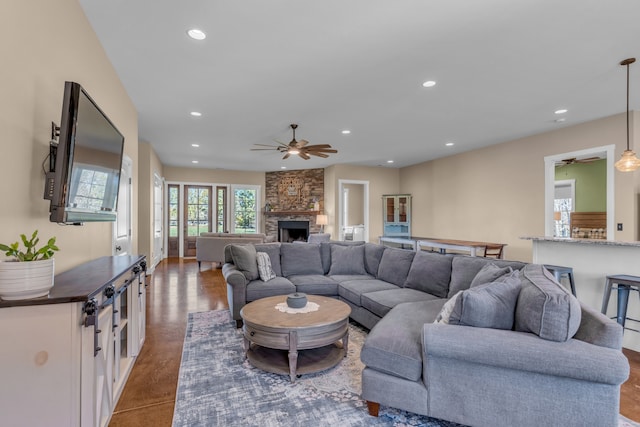 living room featuring a fireplace, hardwood / wood-style flooring, and ceiling fan