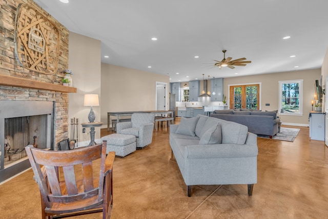 living room featuring a stone fireplace and ceiling fan