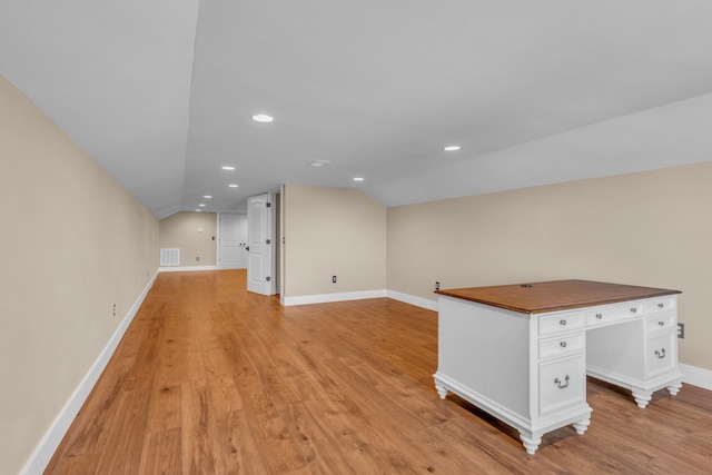 interior space with light wood-type flooring and vaulted ceiling