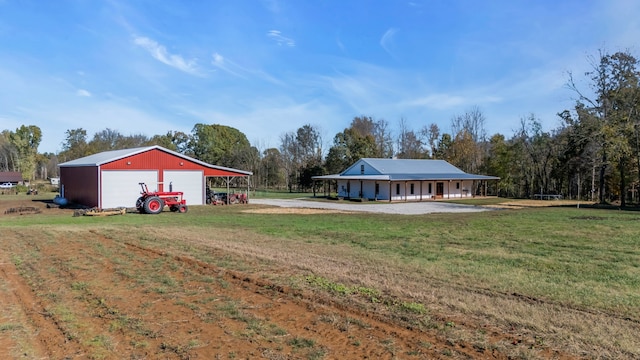 view of yard with an outbuilding, a carport, and a garage