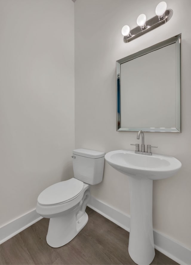 bathroom with hardwood / wood-style flooring and toilet