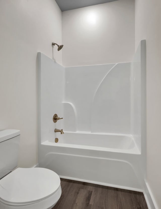 bathroom featuring wood-type flooring, toilet, and shower / bathtub combination