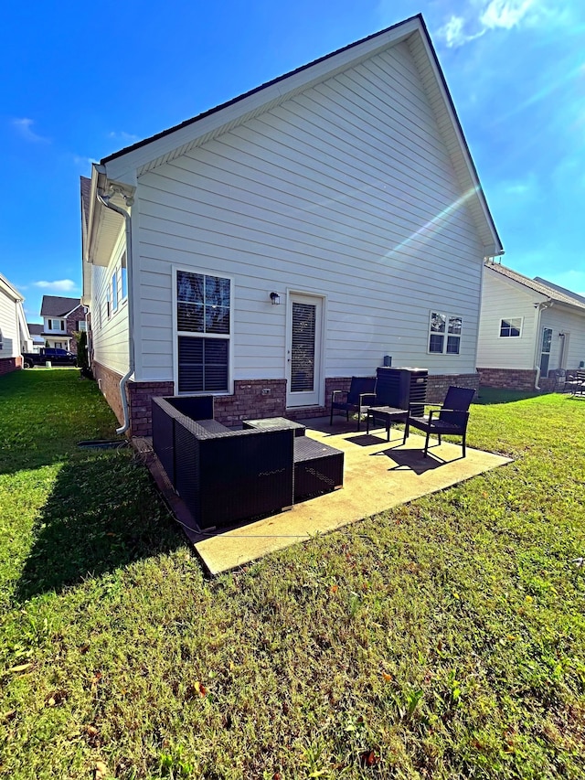 rear view of property with a lawn, an outdoor hangout area, and a patio