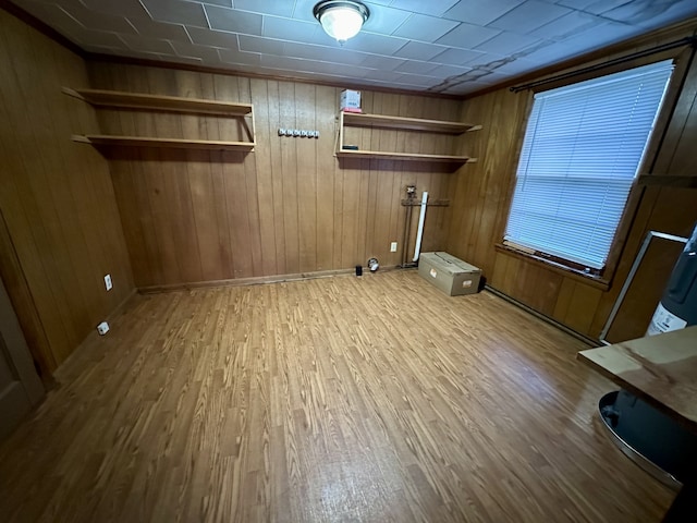 laundry area featuring gas dryer hookup, hardwood / wood-style flooring, and wooden walls