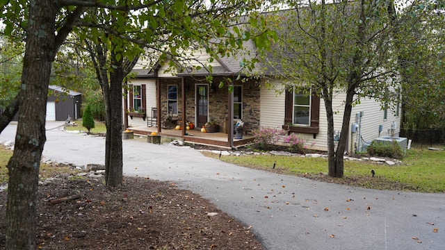 view of front facade featuring covered porch, an outbuilding, and a garage