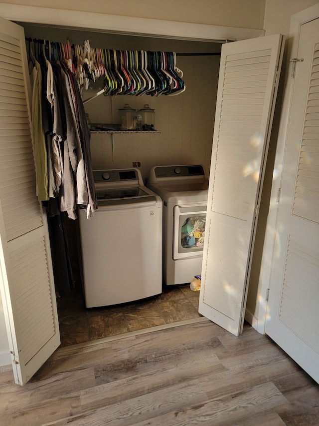 clothes washing area with wood-type flooring and washer and clothes dryer