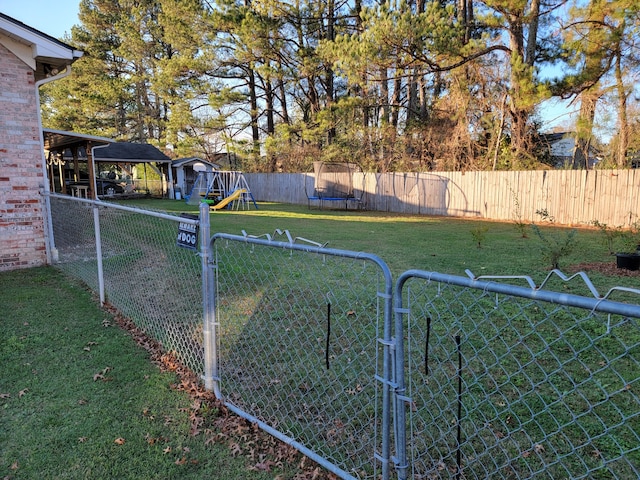 view of yard with a playground and a trampoline