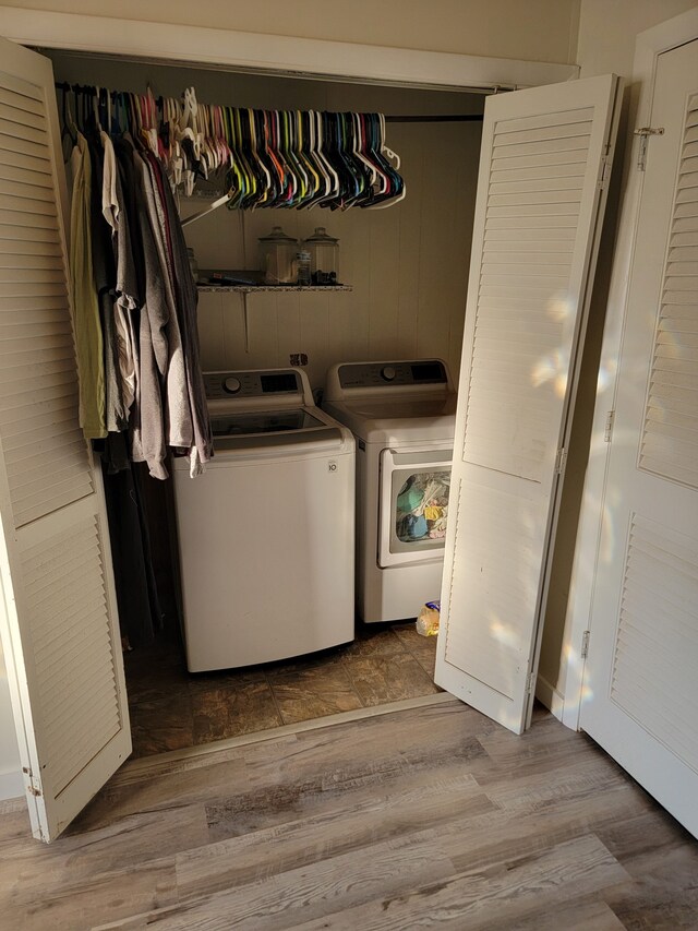 washroom with washer and clothes dryer and wood-type flooring