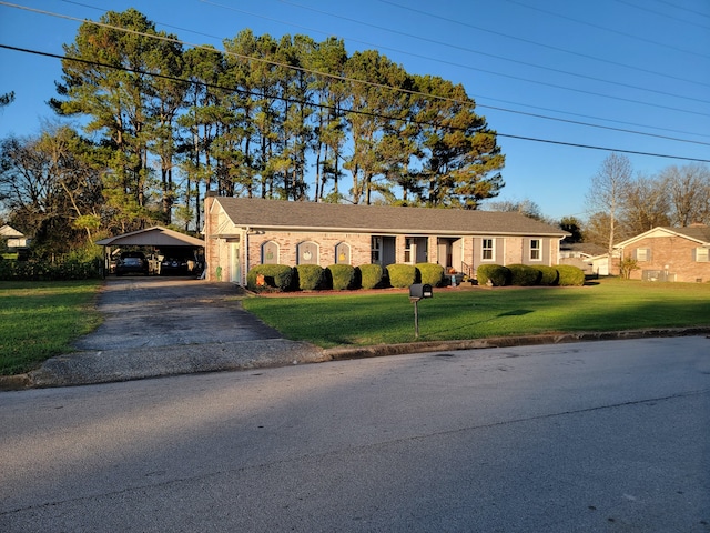 ranch-style house featuring a front yard and a carport