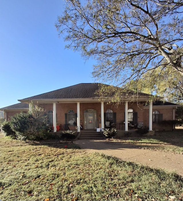 back of house featuring a yard and covered porch