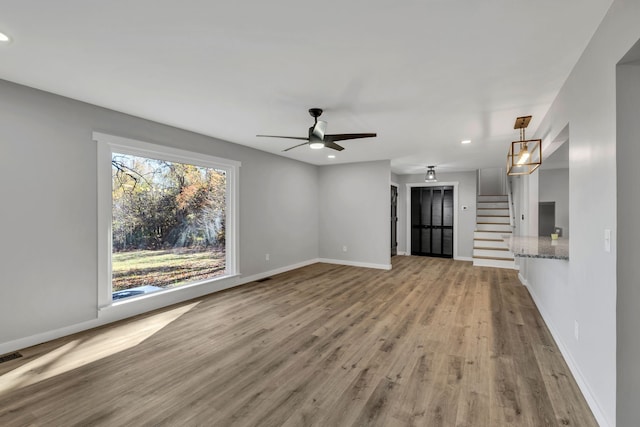 unfurnished living room featuring light hardwood / wood-style floors and ceiling fan