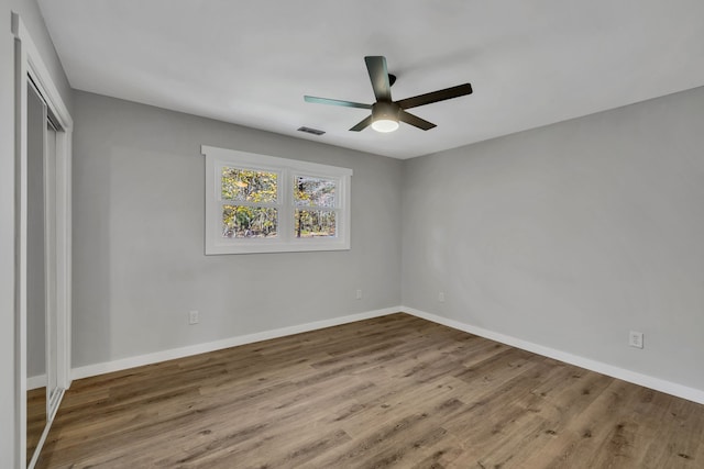 unfurnished bedroom featuring ceiling fan, wood-type flooring, and a closet