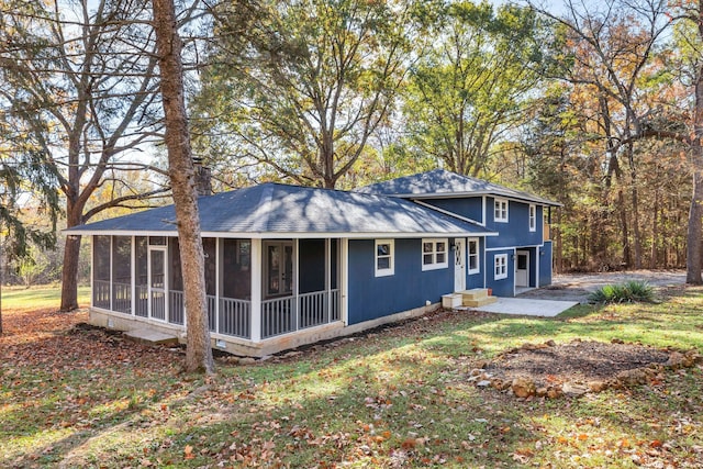 rear view of house with a patio area and a sunroom