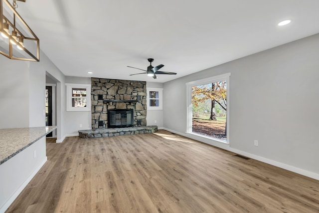 unfurnished living room with a fireplace, light wood-type flooring, and ceiling fan