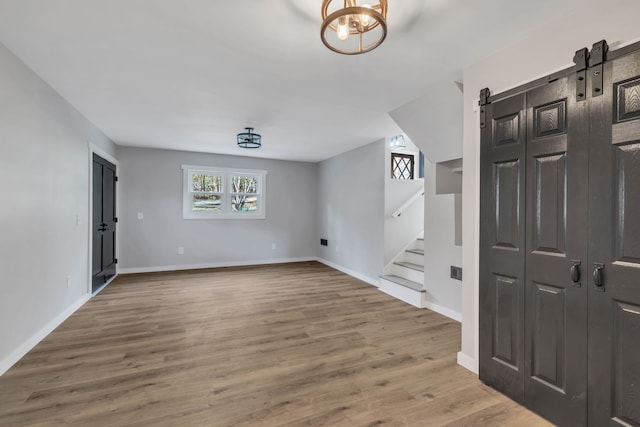 empty room with hardwood / wood-style floors and a barn door