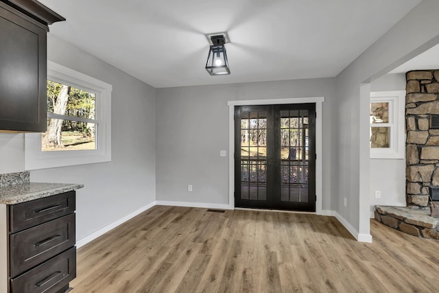 foyer featuring light wood-type flooring and french doors