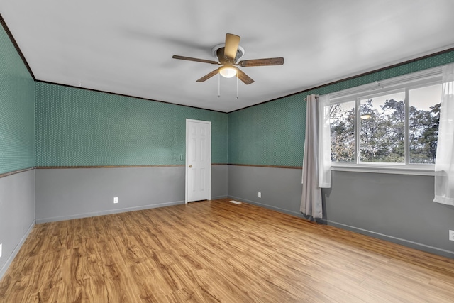 spare room featuring crown molding, ceiling fan, and light wood-type flooring