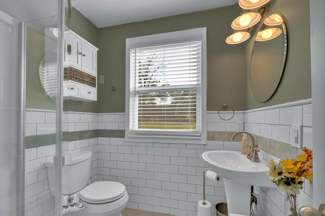 bathroom featuring toilet and tile walls